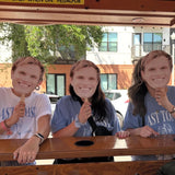 bachelorette group holding up groom cardboard face cutout on pedal pub bike in st pete 