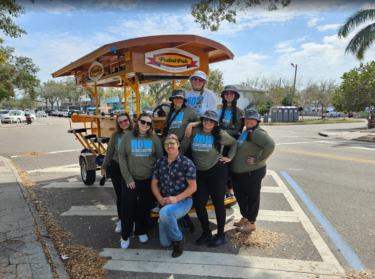bachelorette group in front of pedal bike
