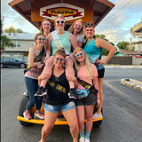 pedalpub tour group on pedal pub smiling bride centered in middle with bride sash and heart sunglasses 